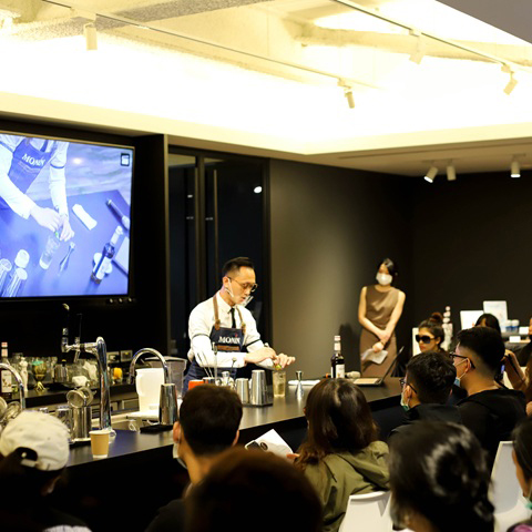 Barista explaining beverage formulation during a lab training session.